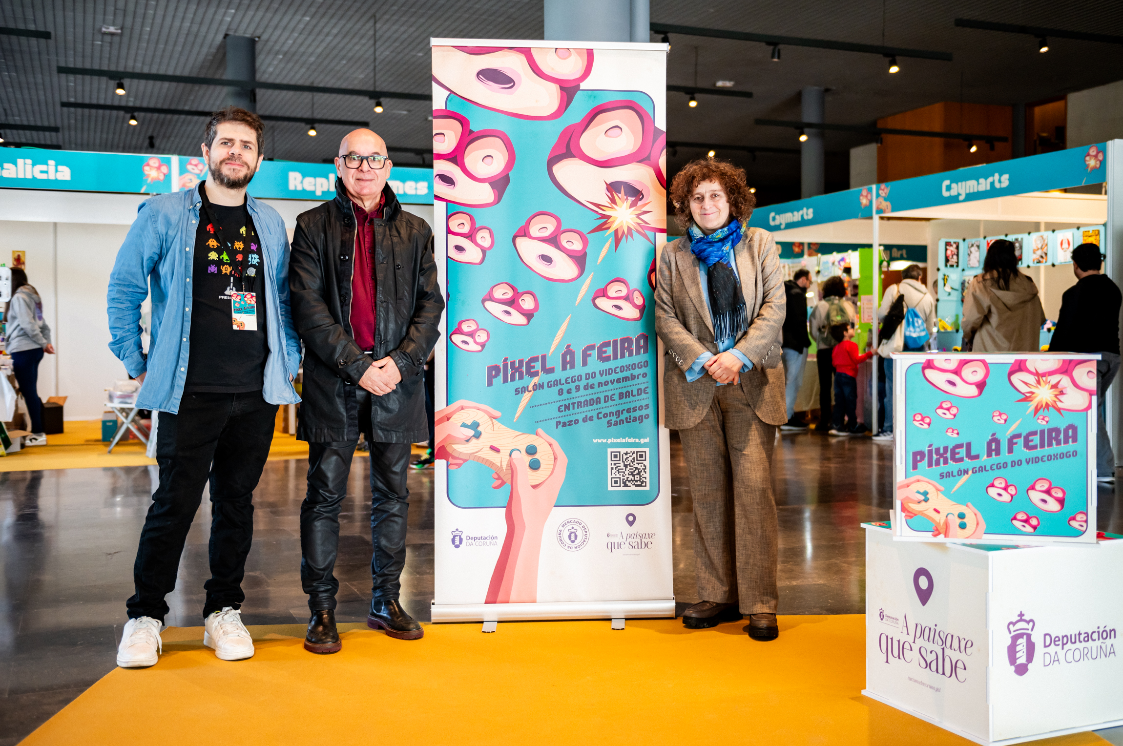 Iago Gordillo, comisario de Píxel á Feira; Xosé Regueira, vicepresidente da Deputación da Coruña; e Goretti Sanmartín, alcaldesa de Santiago. Foto: Leo López